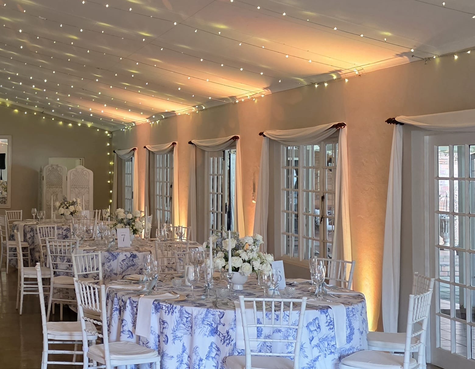 Professional uplighting creating warm ambient lighting at Providence wedding venue, showcasing colorful LED uplights illuminating the reception space