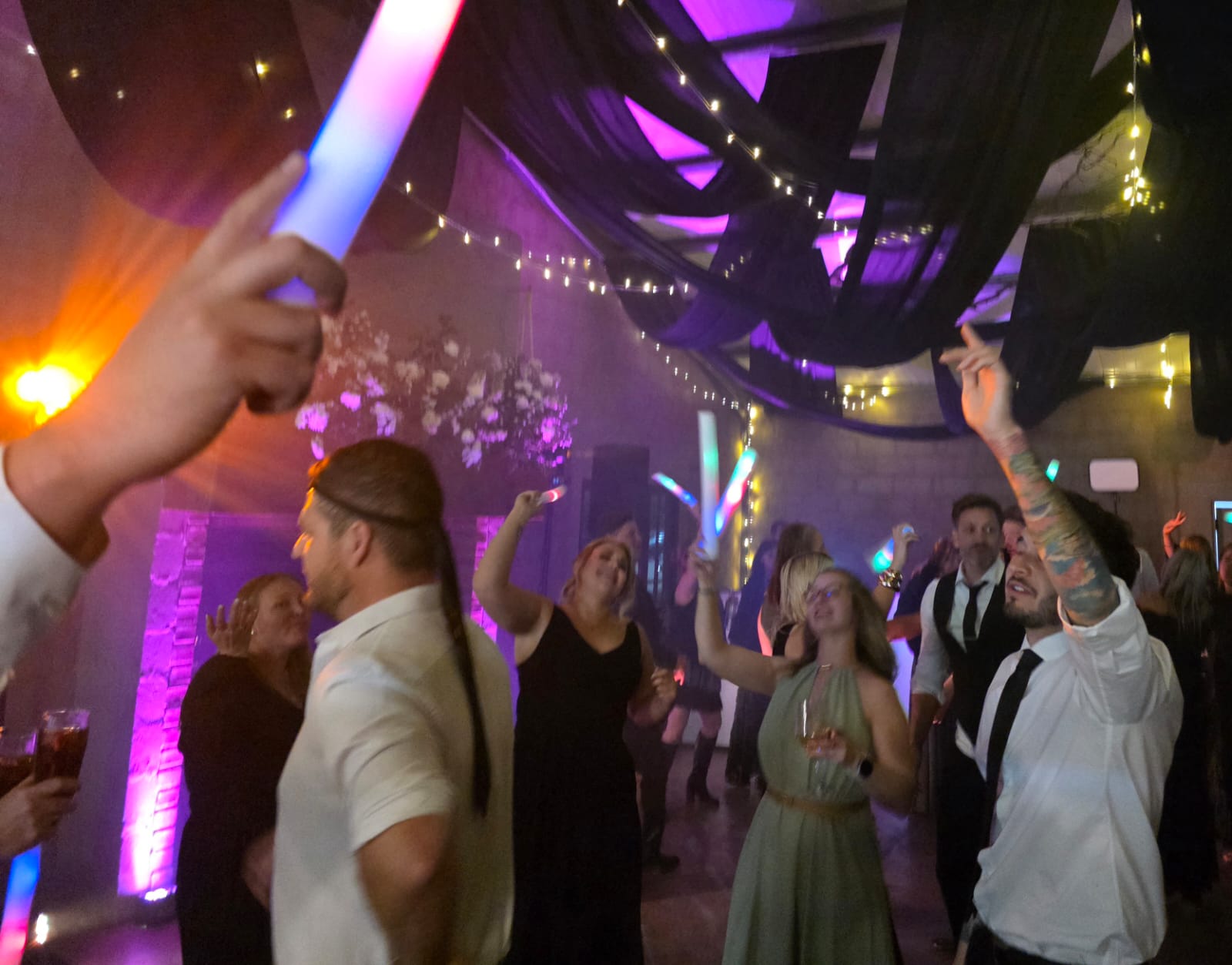 Wedding guests dancing with glowsticks and colorful uplighting at Haycroft Farm venue in Dargle KZN