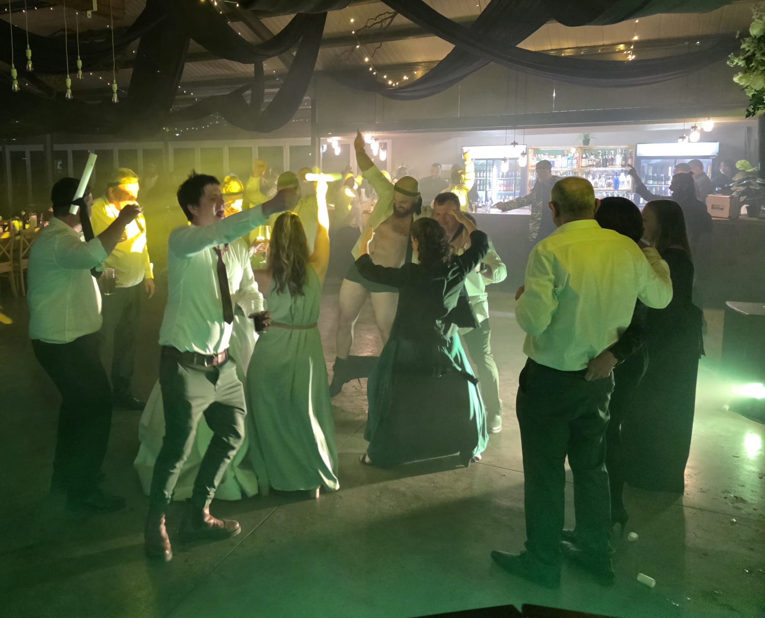Green and yellow uplighting with guests dancing at Haycroft Farm wedding venue in KZN Midlands